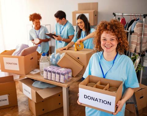 A group of young people preparing items for donation at a non-profit organization.