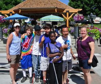 A group of YES-2 interns with DSB Youth Services staffers pose in front of a gazebo during a trip to the Woodland Park Zoo