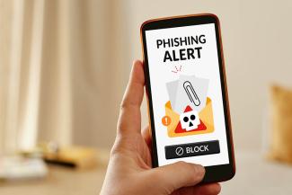 A smartphone with a screen warning of a phishing attack.