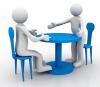 Two 3-d figures meet at table. One sits in a chair. The other is standing and extending their hand for a handshake. Image courtesy of cooldesign on FreeDigitalPhotos.net.