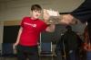 A young man breaks a wooden board with his hand during a self-defense workshop.