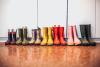 Several pairs of rubber boots. Each pair is a different color and a different size representing members of a family.